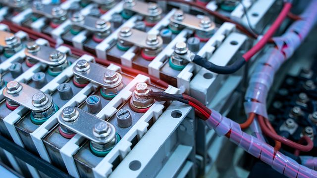 Close-up of connected battery cells with visible wiring and terminals, highlighting industrial energy storage systems. 