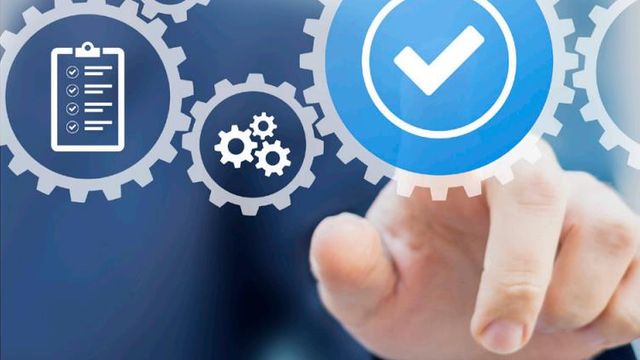 Cogs with clipboard and hand 